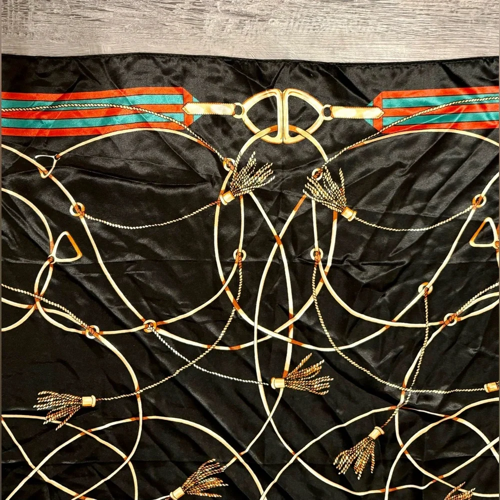 Fashionable women's black scarf with a chain and print. Polyester.